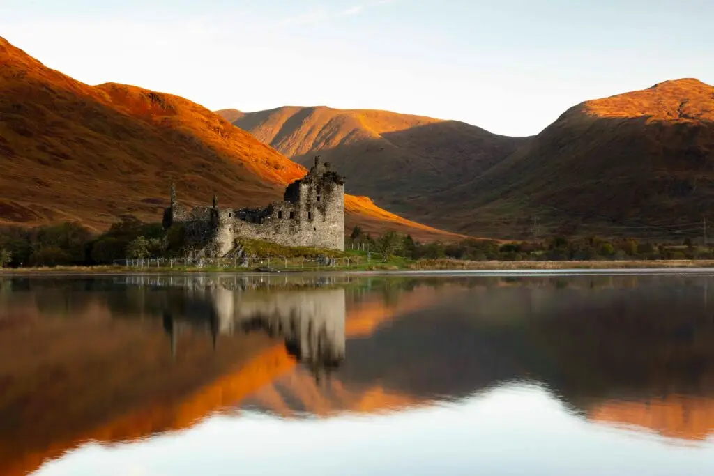 Scottish Highland landscape with a historic castle and mountain backdrop, representing strength, transition and strategic leadership. Livingston James specialises in Interim Executive Search, helping organisations across Scotland and the UK appoint experienced interim executives to lead change, growth and business transformation.